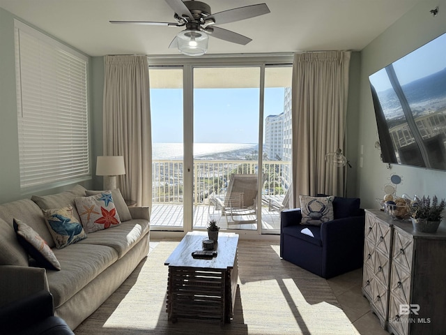 living area featuring a wall of windows, ceiling fan, and a wealth of natural light