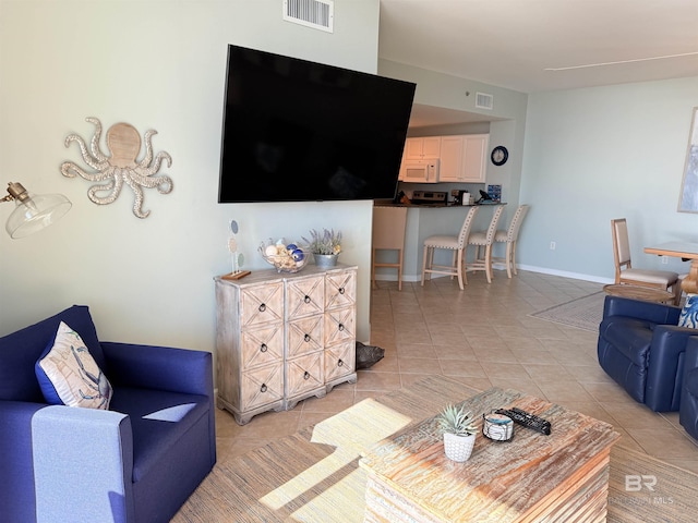 living area with visible vents and light tile patterned floors