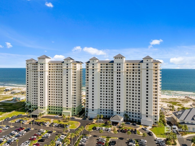 view of building exterior featuring a water view and a beach view