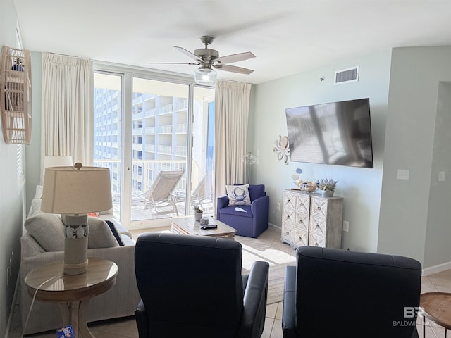 living room with visible vents, ceiling fan, and baseboards