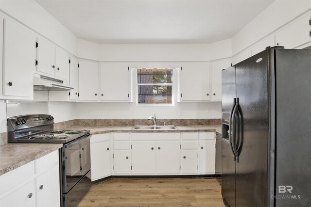 kitchen featuring wood finished floors, a sink, black appliances, white cabinets, and under cabinet range hood