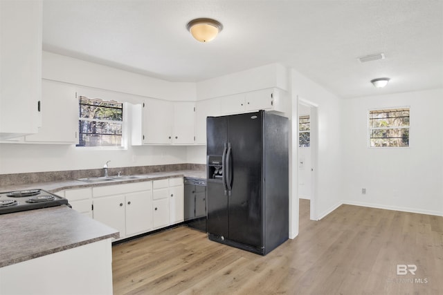 kitchen with a sink, white cabinets, black refrigerator with ice dispenser, and light wood finished floors