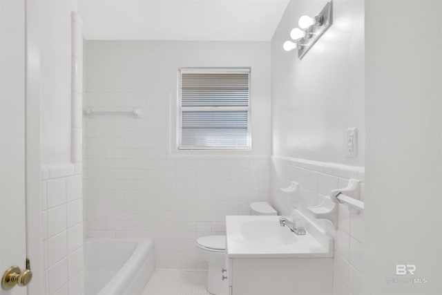 full bath featuring vanity, tile patterned flooring, wainscoting, tile walls, and toilet