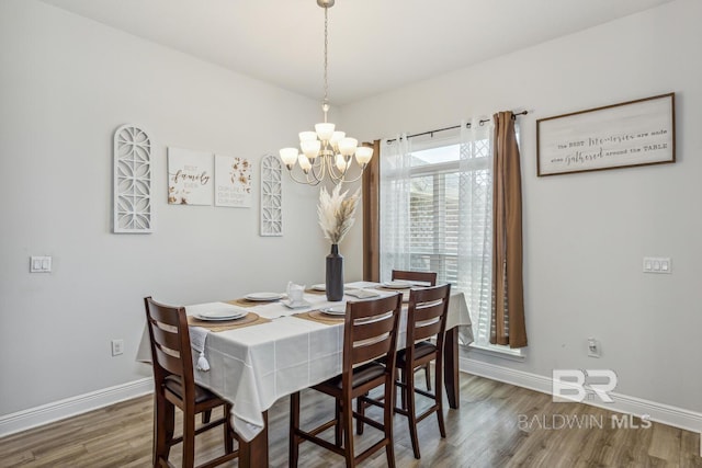 dining room with dark hardwood / wood-style flooring and a notable chandelier