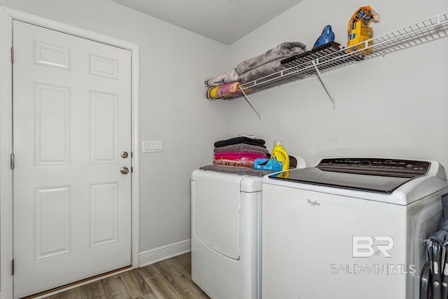 washroom with wood-type flooring and washer and dryer