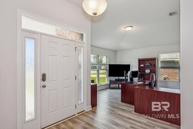 foyer with vaulted ceiling and light hardwood / wood-style floors