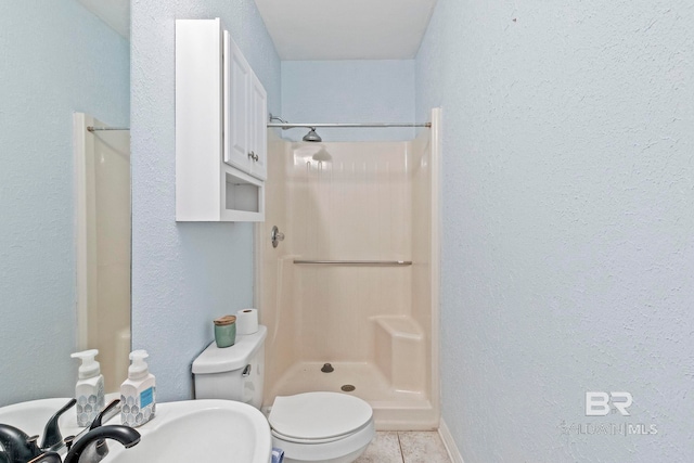 bathroom with tile patterned floors, sink, toilet, and walk in shower