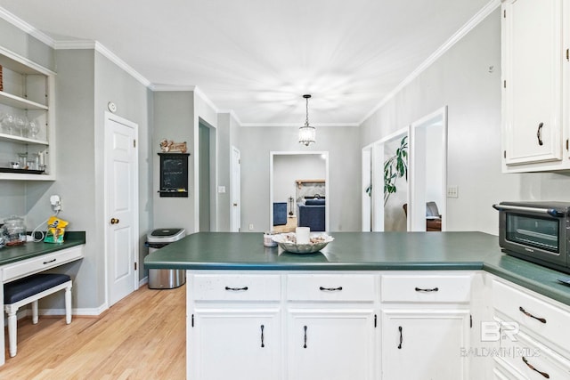 kitchen with hanging light fixtures, ornamental molding, kitchen peninsula, white cabinetry, and light hardwood / wood-style floors