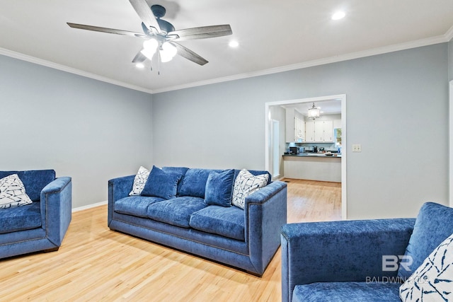 living room featuring ornamental molding, ceiling fan, and wood-type flooring