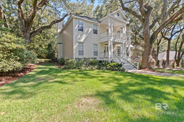 neoclassical home with a front yard and a balcony