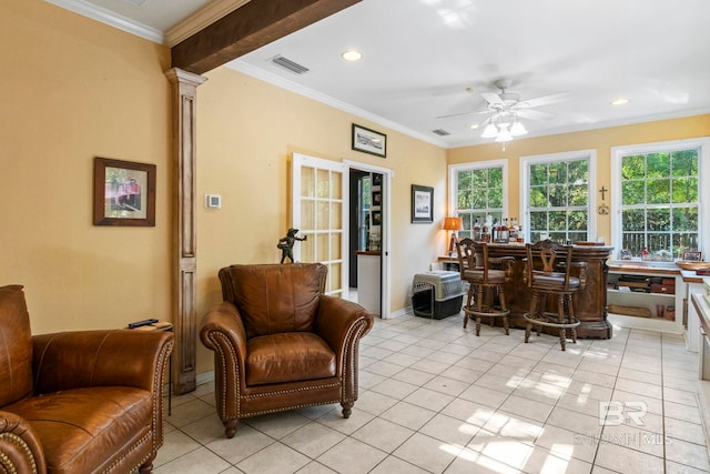 living room featuring bar area, crown molding, ceiling fan, and light tile patterned floors