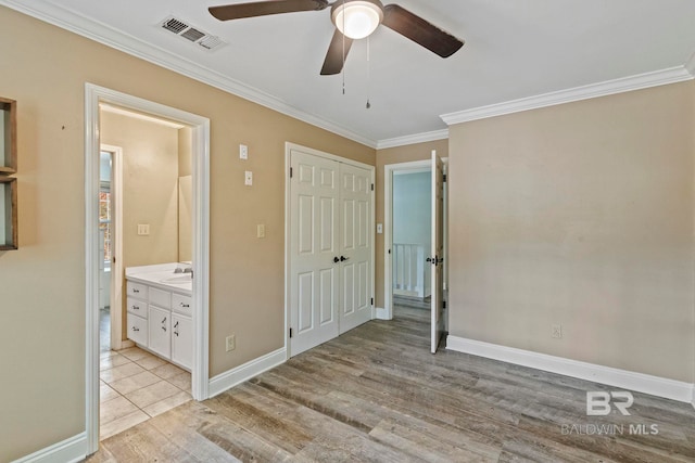 unfurnished bedroom featuring light hardwood / wood-style floors, ceiling fan, crown molding, sink, and connected bathroom