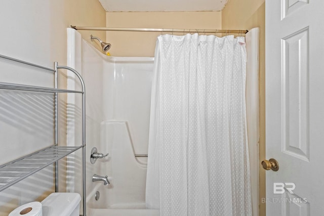 bathroom featuring shower / bath combination with curtain and toilet