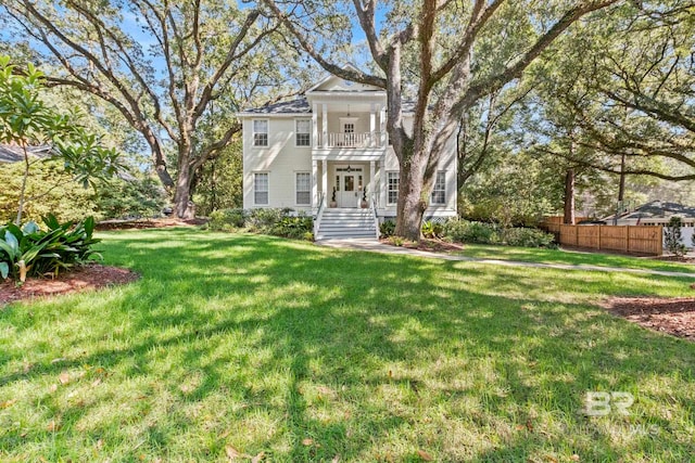 view of front facade featuring a front yard and a balcony