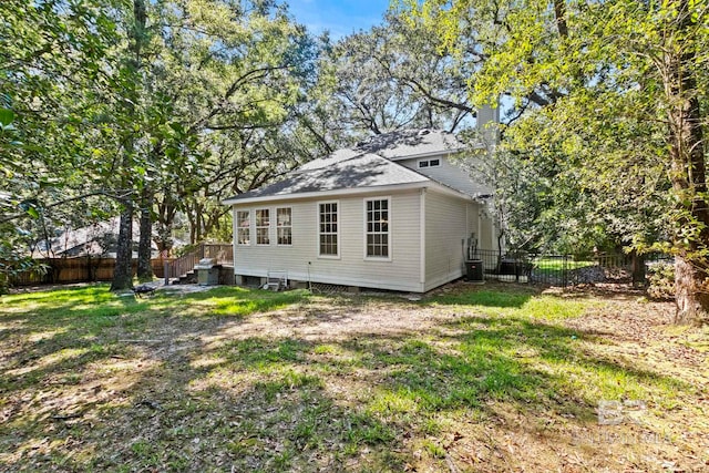 view of home's exterior with cooling unit and a lawn