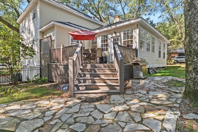 back of property with a deck and a patio