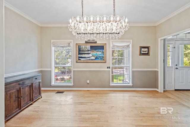 unfurnished dining area featuring a notable chandelier, light hardwood / wood-style flooring, and crown molding