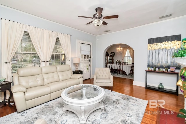 living room with crown molding, ceiling fan with notable chandelier, and wood-type flooring