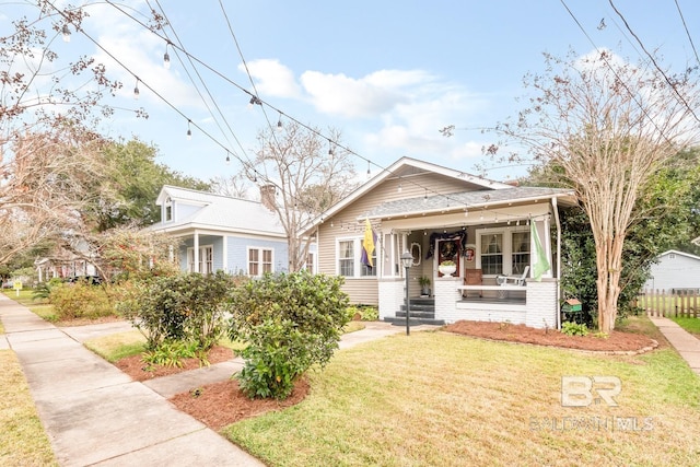 bungalow-style house featuring covered porch and a front lawn