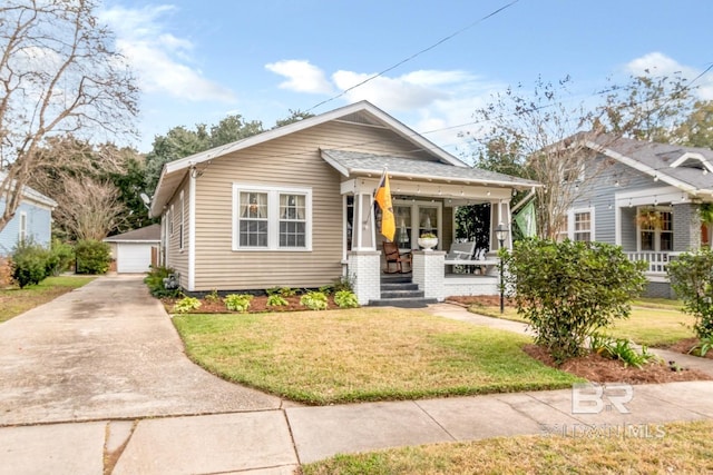 bungalow-style house with a garage, an outdoor structure, a porch, and a front yard