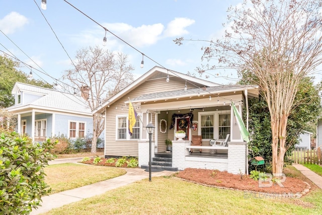 bungalow-style house featuring a front lawn and covered porch