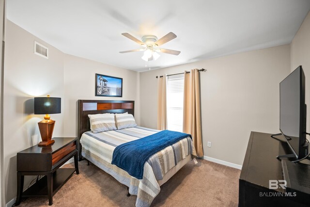 bedroom with baseboards, a ceiling fan, visible vents, and light colored carpet