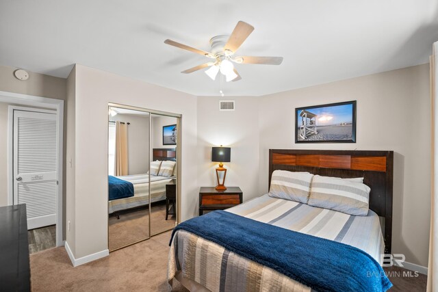 carpeted bedroom featuring a ceiling fan, a closet, visible vents, and baseboards