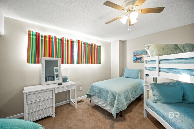 bedroom with a ceiling fan, a textured ceiling, baseboards, and carpet flooring