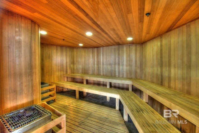 view of sauna / steam room with wood ceiling, hardwood / wood-style flooring, and wooden walls