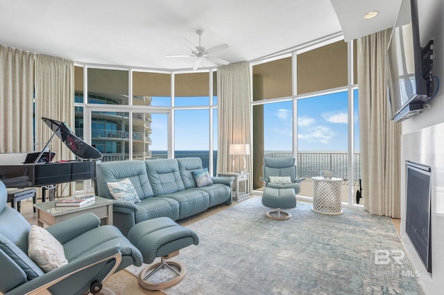 living room with expansive windows and ceiling fan