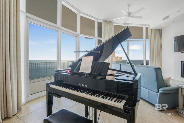 miscellaneous room with light tile patterned flooring, a water view, and a wealth of natural light