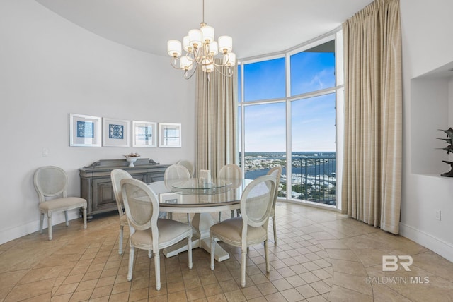 26302 Perdido Beach Blvd Unit D2301, Orange Beach, AL 36561 - dining area with a towering ceiling, light tile patterned floors, baseboards, expansive windows, and a notable chandelier