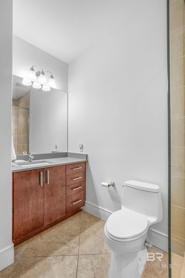 bathroom with vanity, a tile shower, toilet, and tile patterned floors