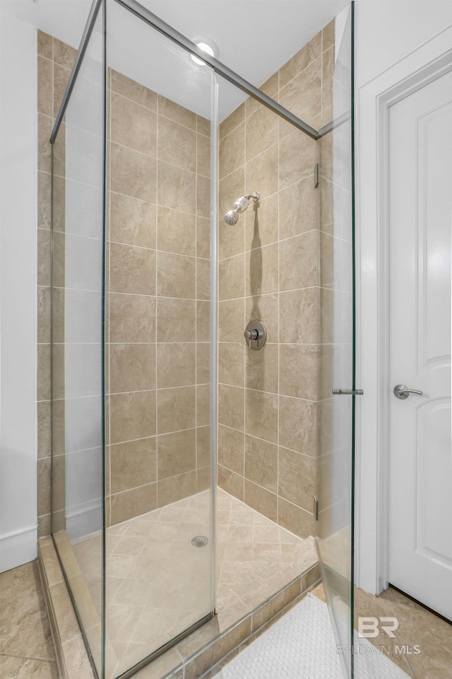 bathroom with a shower with door and tile patterned flooring