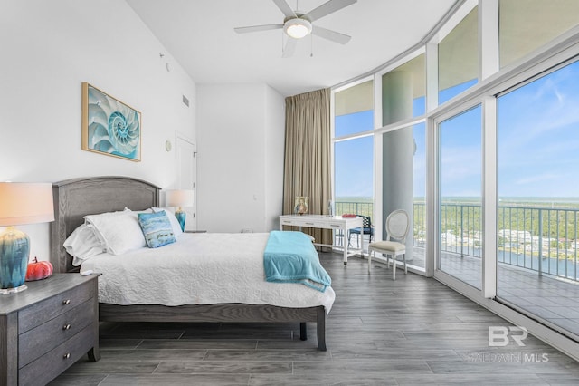 bedroom featuring expansive windows, ceiling fan, access to exterior, and dark hardwood / wood-style flooring