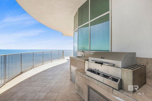 view of patio / terrace featuring a water view, area for grilling, a balcony, and sink