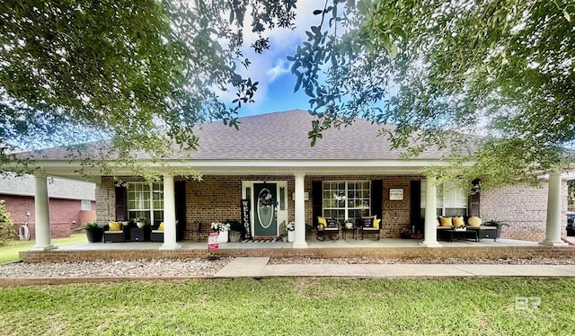 back of house featuring an outdoor hangout area, a yard, a porch, and brick siding