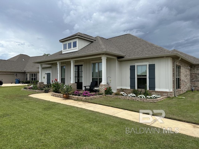 3872 Stafford Blvd, Gulf Shores, AL 36542 - view of front of home featuring board and batten siding, a front lawn, a shingled roof, and a porch