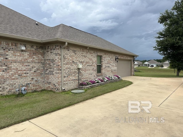 3872 Stafford Blvd, Gulf Shores, AL 36542 - view of side of home with roof with shingles, driveway, brick siding, an attached garage, and a yard
