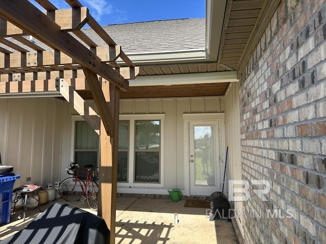 3872 Stafford Blvd, Gulf Shores, AL 36542 - entrance to property with a shingled roof, a pergola, a patio area, and board and batten siding