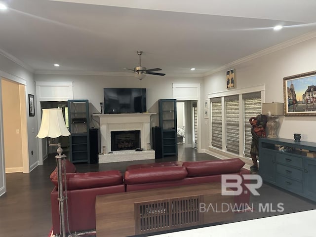 3872 Stafford Blvd, Gulf Shores, AL 36542 - living room featuring a ceiling fan, ornamental molding, recessed lighting, a fireplace with raised hearth, and dark wood-style flooring