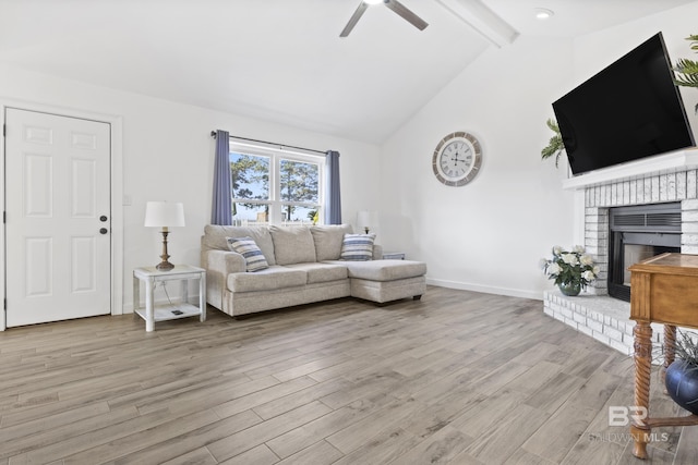 living room with a fireplace, vaulted ceiling with beams, light hardwood / wood-style flooring, and ceiling fan