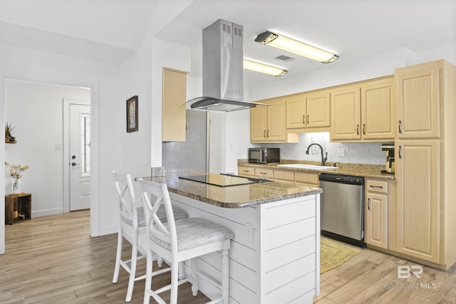 kitchen featuring sink, island exhaust hood, kitchen peninsula, a kitchen bar, and black appliances