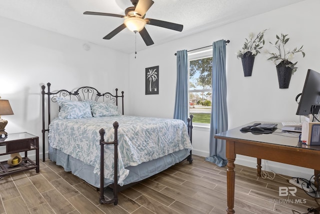 bedroom with ceiling fan and a textured ceiling