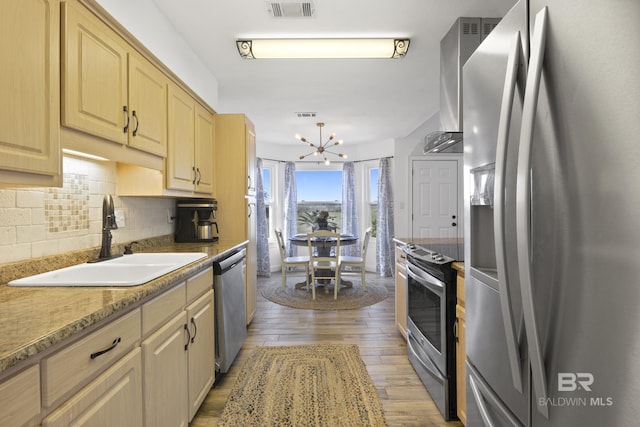 kitchen featuring sink, light brown cabinetry, tasteful backsplash, appliances with stainless steel finishes, and a chandelier