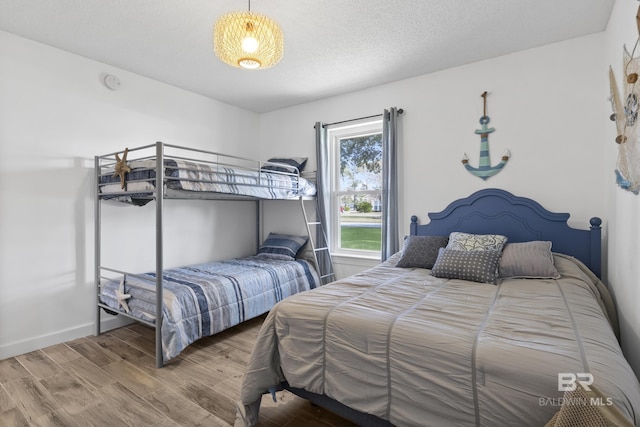 bedroom with a textured ceiling and hardwood / wood-style flooring