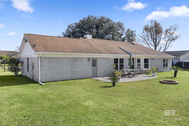 rear view of house featuring a fire pit, a yard, and a patio