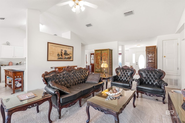 carpeted living room with ceiling fan and vaulted ceiling