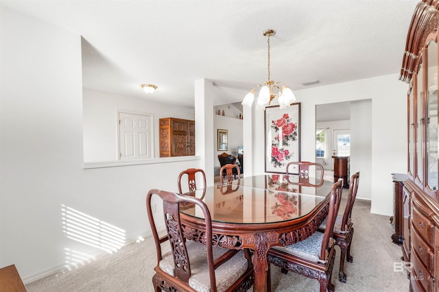 dining room with a chandelier, carpet floors, and a textured ceiling