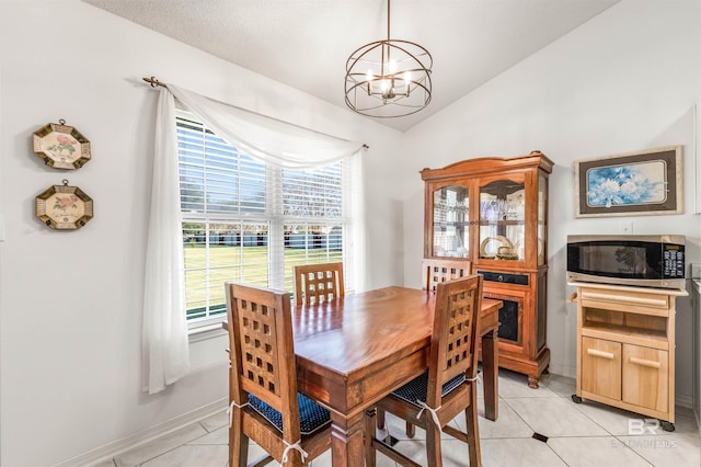 dining area featuring lofted ceiling, a chandelier, plenty of natural light, and light tile patterned floors